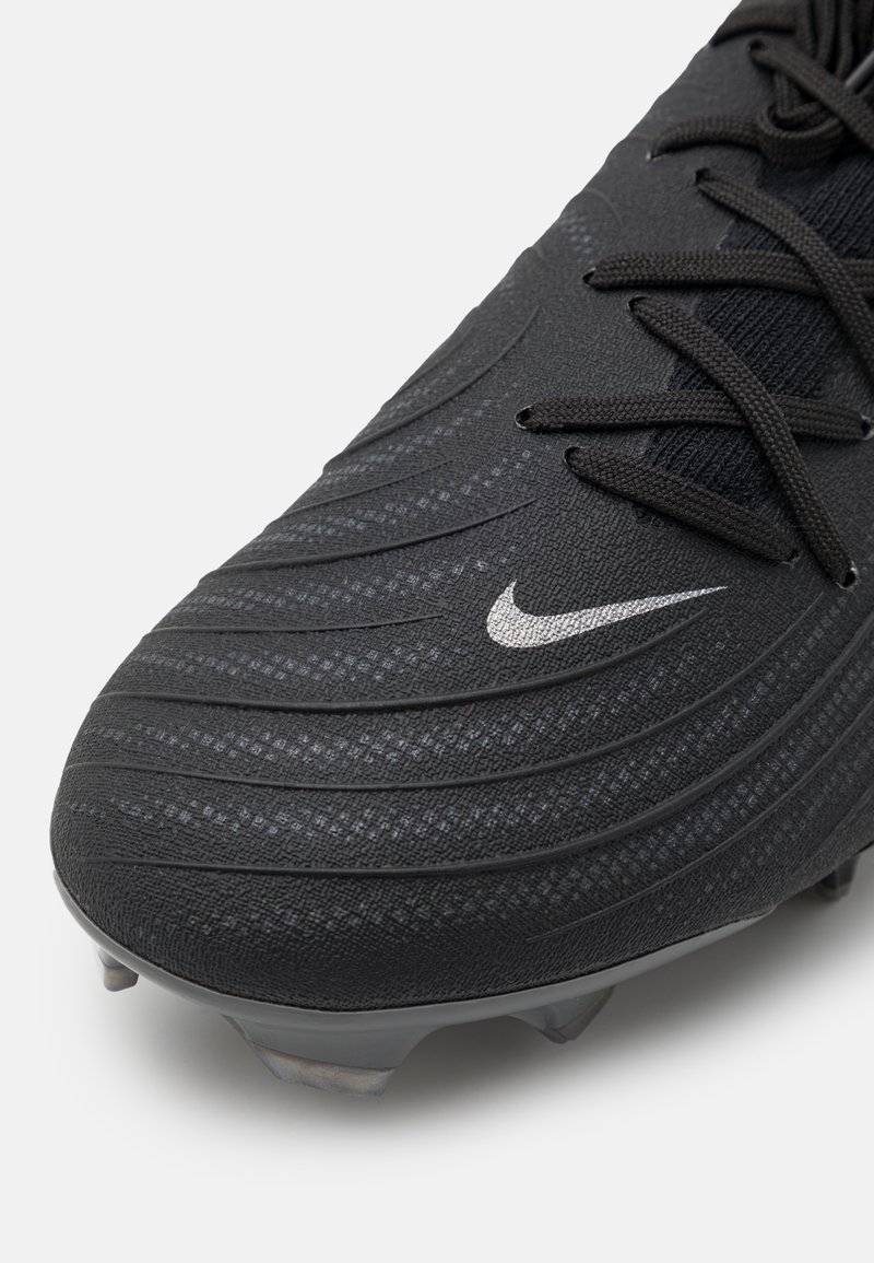 Botas de fútbol negras con un upper texturizado y costillas curvadas, logotipo de Nike en plata y tacos de plástico grises para una mejor tracción en superficies de hierba.