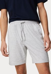 Pantalones cortos de algodón gris con cintura elástica y cordón ajustable. Textura suave, hasta la rodilla y diseño sencillo.
