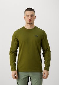Olívazöld, hosszú ujjú, kerek nyakú pamut ing, fekete logóval a bal mellrészen és sima felülettel.