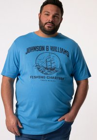 Modré bavlněné tričko s krátkým rukávem, se stylovým potiskem lodi a textem "Johnson & Williams Fishing Charters" v černé barvě.