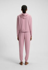 Rosa sweatshirt med huva, kort design, tillsammans med matchande rosa sweatpants. Mjuk textur, ribbade manschetter vid ärmar och anklar.