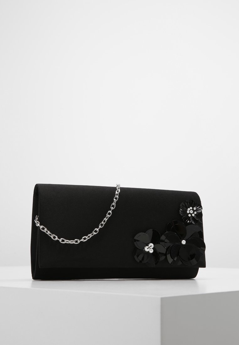Bolso de mano negro con un diseño elegante, hecho de tela texturizada. Presenta adornos florales y una correa de cadena plateada.