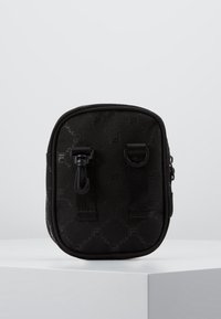 Czarna materiałowa torba z teksturowanym wzorem logo, zamkiem błyskawicznym i dwoma paskami. Kompaktowy, prostokątny kształt, odpowiedni na małe przedmioty.