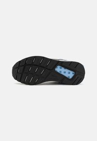 Black rubber shoe sole with a blue hexagonal pattern insert, featuring grooves for traction and a logo embossed on the side.
