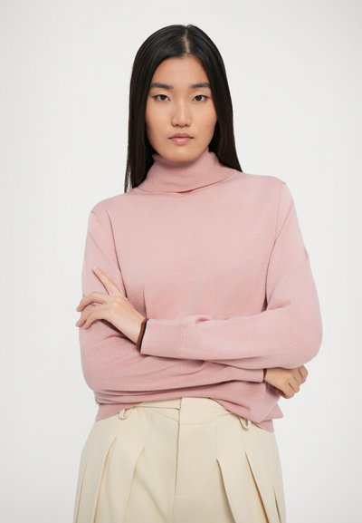 Pullover a collo alto rosa chiaro con texture a coste e maniche aderenti, abbinato a pantaloni plissettati crema. Design semplice e moderno.