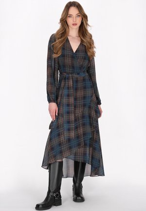 Pitkä ruudullinen mekko, joka on valmistettu läpinäkyvästä kankaasta tummansinisessä, punaisessa ja valkoisessa, ja jossa on kietaisumalli, pitkät hihat ja solmittava vyötärödetail. Yhdistetty mustiin polven yli ulottuviin saappaisiin.