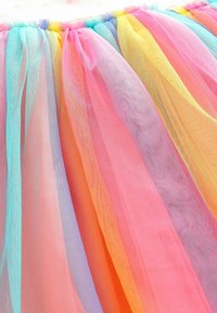 Multifärgad tylltyg i pastellnyanser av rosa, gult, blått, orange och violett, med en mjuk, luftig textur och rynkad design.