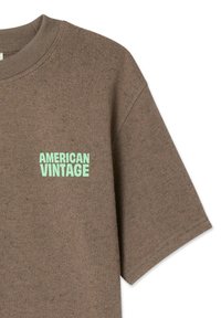 T-shirt marrone a maniche corte con scollo tondo, con logo "AMERICAN VINTAGE" verde menta sul lato sinistro del petto. Tessuto a trama strutturata.