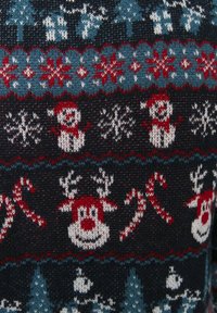 Stickad jultröja med en marinblå bas och röda och teal mönster, inklusive snöflingor, snögubbar, renar och godistänger.