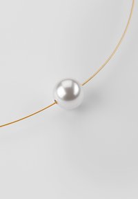Gouden draad halsketting met een ronde, glanzende witte parel in het midden. Gladde oppervlakte met een reflecterende glans. Eenvoudig, minimalistisch ontwerp.