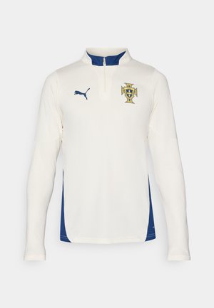 Puma langærmet trøje i cremefarve med blå sidepaneler. Har en halv-lynlås krave og broderet badge på brystet. Struktureret stof.