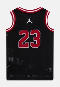 Czarna koszulka do koszykówki z czerwonym i białym wykończeniem, numer 23 w czerwieni z białym konturem, a nad numerem znajduje się białe logo Jumpman.