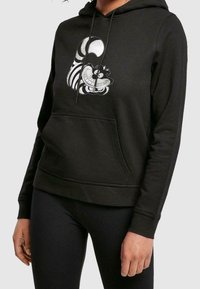 Zwarte hoodie gemaakt van katoenmix. Voorzien van een voorkantzak en een grafische print van een glimlachend personage in wit en grijs op de borst.