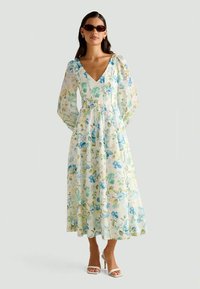 Blomster maxi-kjole med lange, puffede ærmer i let stof, med blå og grønne blomster mønstre, V-udskæring og snor i taljen.