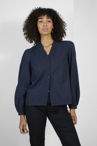 Blouse bleu marine avec un décolleté en V, des manches longues bouffantes, un devant à boutons et des détails texturés le long du col. Tissu lisse.