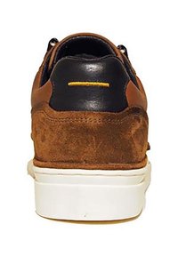 Brown suede and black leather sneaker with a white rubber sole and yellow accent stitch on the heel, featuring a rounded design.