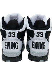 Čierno-biele vysoké tenisky s textúrovanými panelmi, výrazným tlmením a vyšitými "33" a "EWING" na päte.