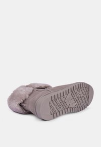 Stivale in suede grigio con un morbido rivestimento in pelle di pelliccia, caratterizzato da una suola in gomma con presa testurizzata e una cerniera laterale per la chiusura.