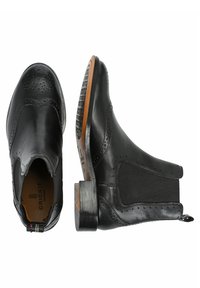 Stivali alla caviglia in pelle nera con pannelli elastici laterali, dettagli brogue, tacco basso e suola testurizzata per una migliore aderenza.