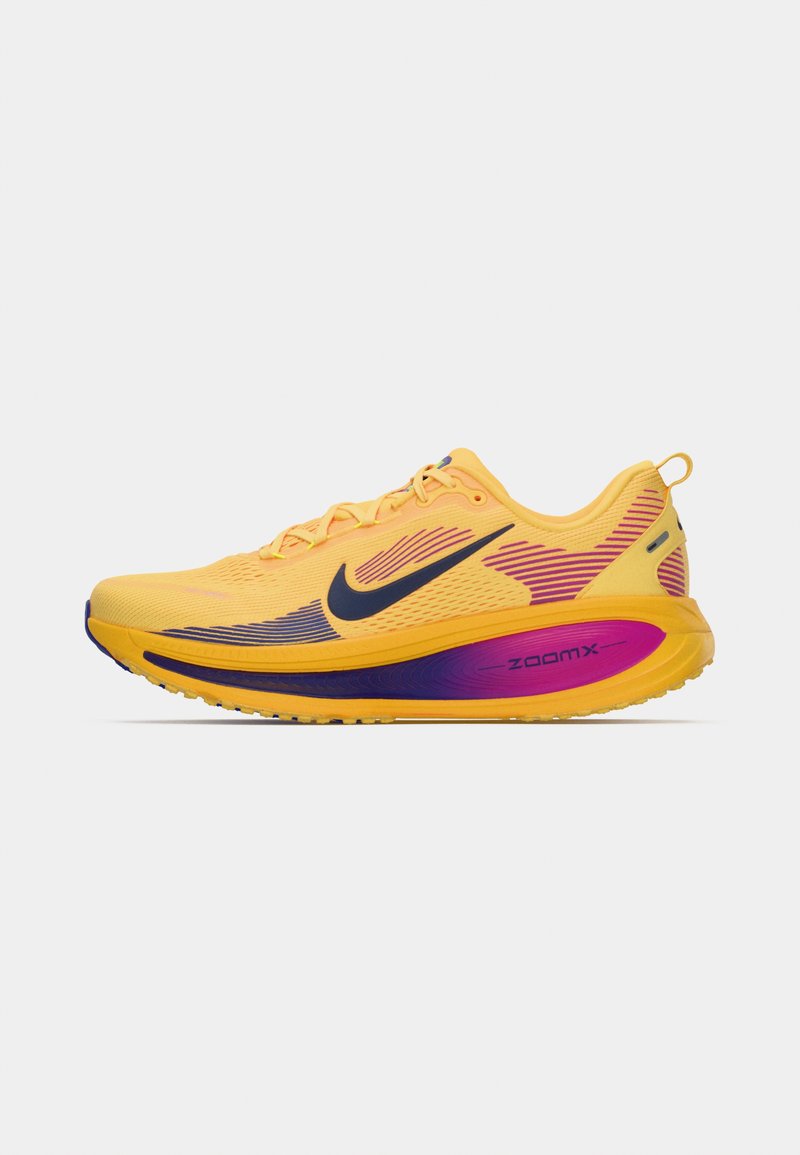 Zapatilla de correr Nike con parte superior de malla en amarillo brillante, acentos en degradado púrpura y una plantilla acolchada "ZoomX" destacada.