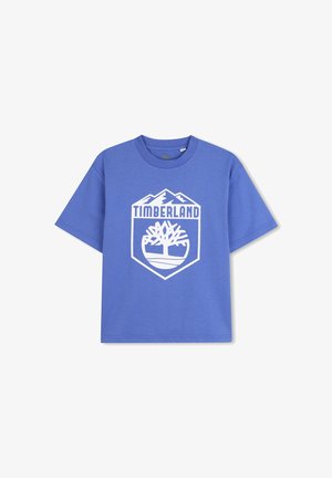 Blauw katoenen T-shirt met een witte afgedrukte Timberland-logo binnen een schildontwerp, met berggraphics erboven en een boommotief eronder.