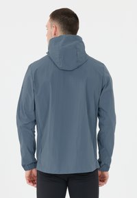 Herrjacka med huood i ljusblått med en slät textur, elastiska ärmslut och en minimalistisk design, med en diskret logotyp på ärmen.