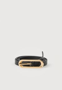 Ceinture en cuir noir enroulée avec une boucle ovale allongée brillante en or sur un fond blanc.