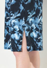 Abito con motivo floreale in blu navy scuro con tonalità di blu. Tessuto morbido, lunghezza al ginocchio con uno spacco laterale, che mette in mostra design di fiori stilizzati.
