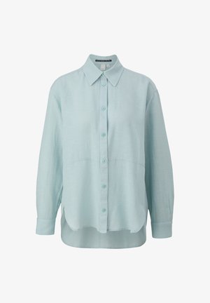 Hellblaues Leinenhemd mit spitzem Kragen, Knopfleiste, langen Ärmeln und abgerundetem Saum. Weiche Textur, leicht übergroße Passform.