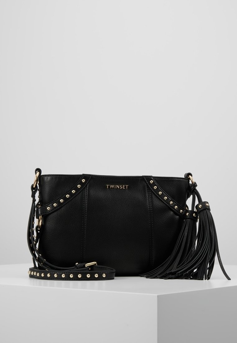 Borsa in pelle nera con accenti borchiati, una tracolla con frange e un logo dorato. Presenta un design strutturato e una tracolla regolabile.