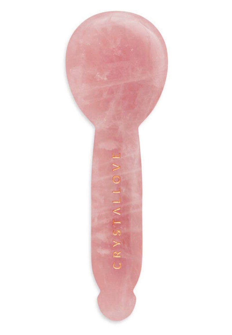 Rozenkwarts gezichtsapparaat met een glad, rond bovenkant en een platte handgreep, met een gouden reliëftekst "CRYSTALLOVE".