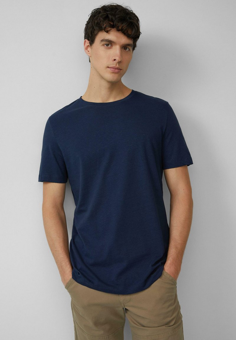 Marineblaue kurzärmelige T-Shirt aus weichem Stoff mit Rundhalsausschnitt, in lockerer Passform und schlichtem Design, kombiniert mit khakifarbenen Hosen.