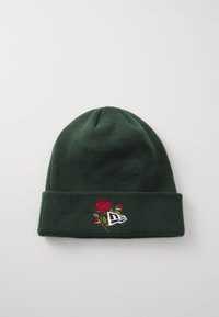 Grüne Strickmütze mit umgeschlagenem Bündchen, verziert mit roter Rosenstickerei und einem weißen Logo. Weiche Textur, zylindrische Form und warmes Design.