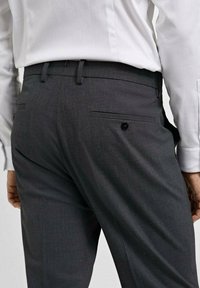 Sive karirane hlače ravnog kroja, s dva stražnja džepa, elegantnim pojasom i suptilnom teksturom.