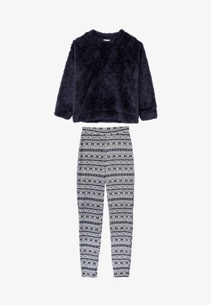 Granatowy, miękki top z wzorem serca i długimi rękawami, zestawiony z białymi legginsami ozdobionymi niebieskimi wzorami plemiennymi. Miękkie i teksturowane materiały.