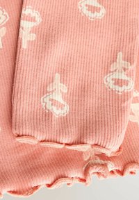 Pfirsichfarbenes Rippgewebe mit weißen Blumen- und Blattmustern, mit gerafften Kanten am unteren Rand. Weiche Textur und sanfter Glanz.