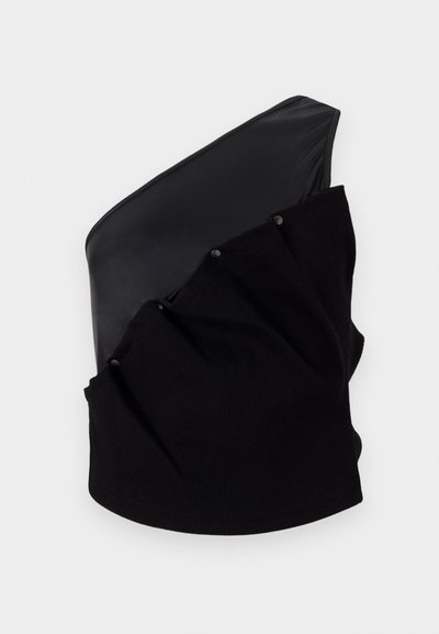 Haut asymétrique noir avec un panneau en cuir lisse et un tissu tricoté texturé, doté de détails froncés et de boutons-pression.