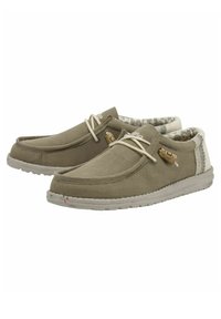 Zapatillas de lona grises con suelas de goma beige. Las características incluyen cordones de color claro, un borde superior texturizado y un acento de corcho en el lateral.