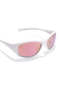 Occhiali da sole bianchi con un design elegante e angolare e lenti rosa chiaro. Contrassegnati con "HAWKERS" sul lato. Texture liscia.