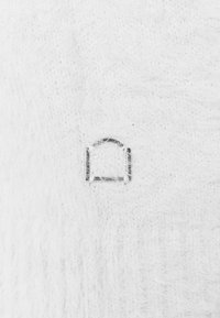 White textured material with a visible silver metallic hardware piece shaped like an arched doorway, set against a soft background.