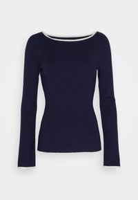 Tmavě modrý dlouhý rukáv přiléhavý svetr s bílým lemem kolem lodičkového výstřihu a manžet rukávů na jednobarevném pozadí.