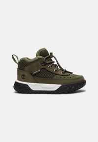 Chaussure de randonnée robuste olive et noire avec panneaux en mesh, lacets auto-agrippants, semelle intermédiaire blanche et languette de tirage au talon.