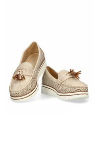 Mocasines de cuero beige con diseño perforado, borlas decorativas y una suela blanca texturizada. Presenta detalles de costura y sutiles acentos marrones.