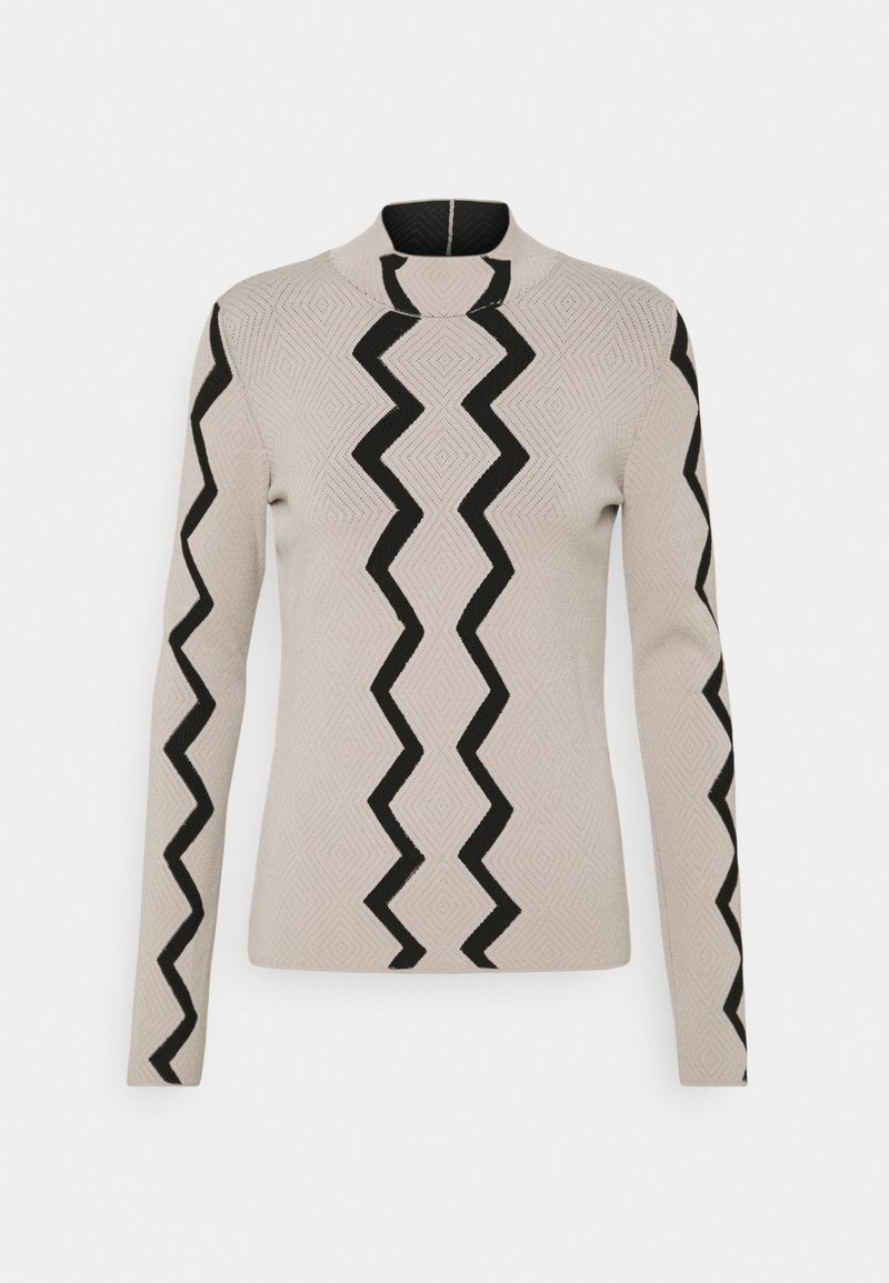 Pull en maille beige à manches longues avec des motifs zébrés noirs au centre devant et le long des manches, avec un col rond montant.