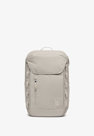 Mochila gris claro con una tela suave y duradera. Cuenta con un bolsillo frontal con cremallera, correas laterales y un asa superior para facilitar el transporte.