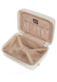Valigia rigida bianca con apertura a zip. L'interno presenta una fodera rosa chiaro, tasche e cinghie elastiche per fissare il contenuto.