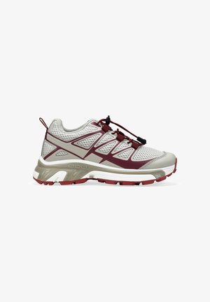 Zapatilla deportiva en gris claro y burdeos con parte superior de malla, cordones elásticos ajustables y suela resistente para actividades al aire libre.