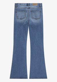 Jeans in denim blu a gamba svasata con vita media, dotati di cinque tasche e un'etichetta del marchio beige sulla banda di vita posteriore.