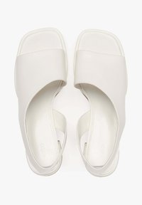 Białe klapki slip-on z gładką skórzaną powierzchnią, kwadratowym noskiem i otwartym tyłem z szerokimi krzyżującymi się paskami.