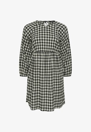 Vestido a cuadros en blanco y negro con cuello redondo y detalle de lazo en la parte posterior, que cuenta con mangas largas y una silueta holgada.